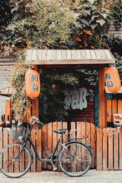 棕色木墙旁的黑色城市自行车